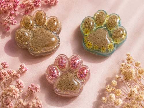 Custom cremation paw print memorial magnets in gold glitter, blue with daisies, and pink holographic glitter resin styles