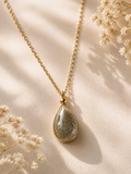 Gold bezel teardrop cremation memorial necklace with natural ash-tone clear resin pendant on delicate gold chain
